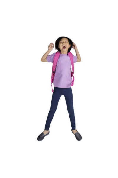 白い背景に分離されたスタジオで跳躍しながらバックパックを運ぶ幸せの少女の肖像画 — ストック写真