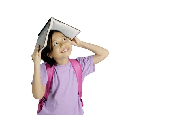 Imagen Una Niña Pensativa Poniéndose Libro Cabeza Mientras Está Pie — Foto de Stock