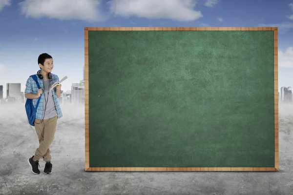 Picture Asian Preteen Student Holding Book While Standing Blank Chalkboard — Stock Photo, Image