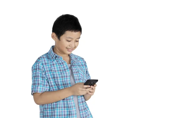 Obrázek Nedospělý Chlapec Psaní Sms Jeho Smartphone Stoje Ateliéru — Stock fotografie