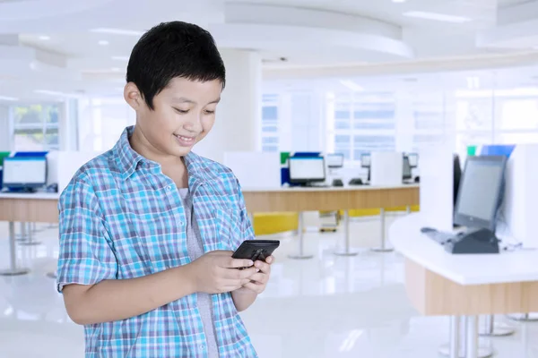 亚洲青春期男孩学生在校时使用智能手机的图片 — 图库照片
