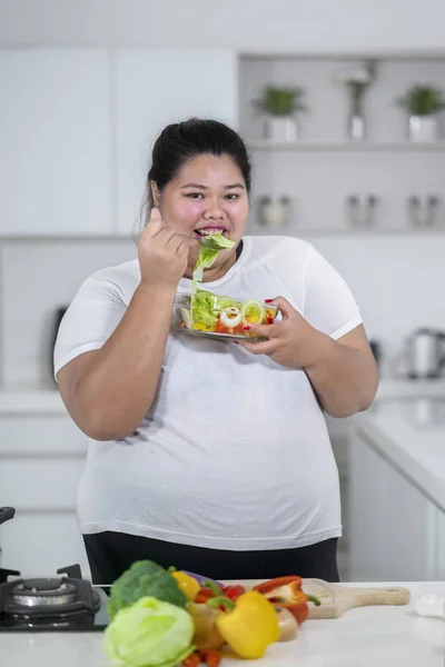 Glad Överviktig Kvinna Äta Sallad Köket — Stockfoto