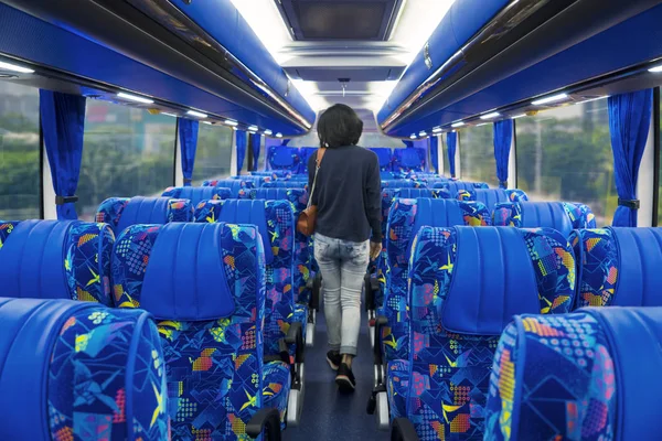 観光バスで自分の席まで歩いて女性旅客の背面図 — ストック写真