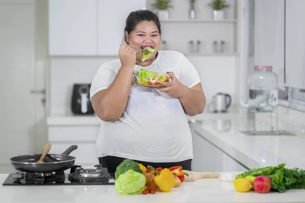 Mutlu Güzel Kilolu Kadın Mutfakta Salata Yemek — Stok fotoğraf