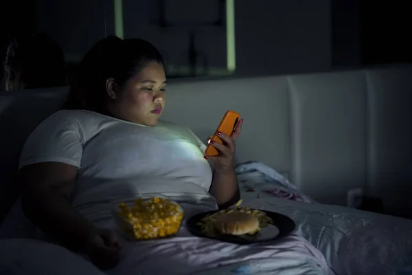 Mujer Con Sobrepeso Usando Teléfono Móvil Mientras Come Comida Chatarra — Foto de Stock