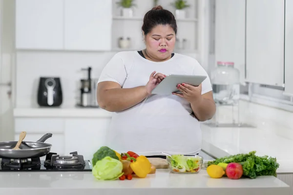 超重妇女看数字片剂为健康膳食食谱 — 图库照片