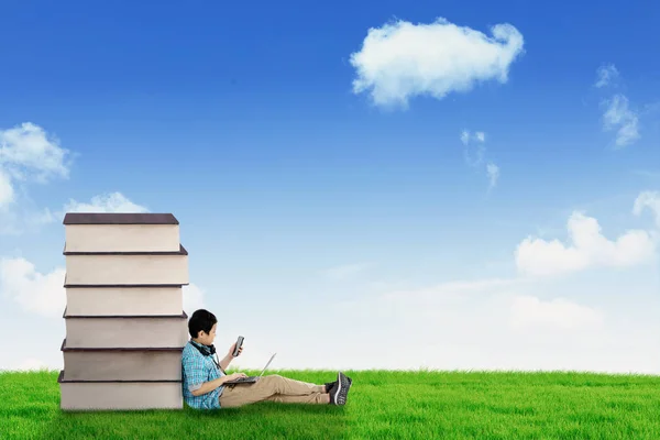 Schulkind Mit Laptop Und Smartphone Während Neben Einem Stapel Bücher — Stockfoto
