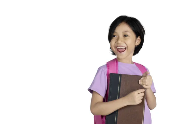 かわいい女子高生は 白い背景で隔離 スタジオで本を運んでいる間幸せそうに見える — ストック写真