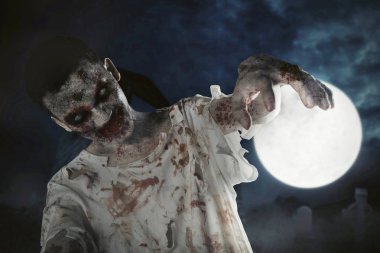 Halloween korku kavramı: dolunay arka planlı mezar üzerinde yürüyen bir korkunç zombi adam yakın