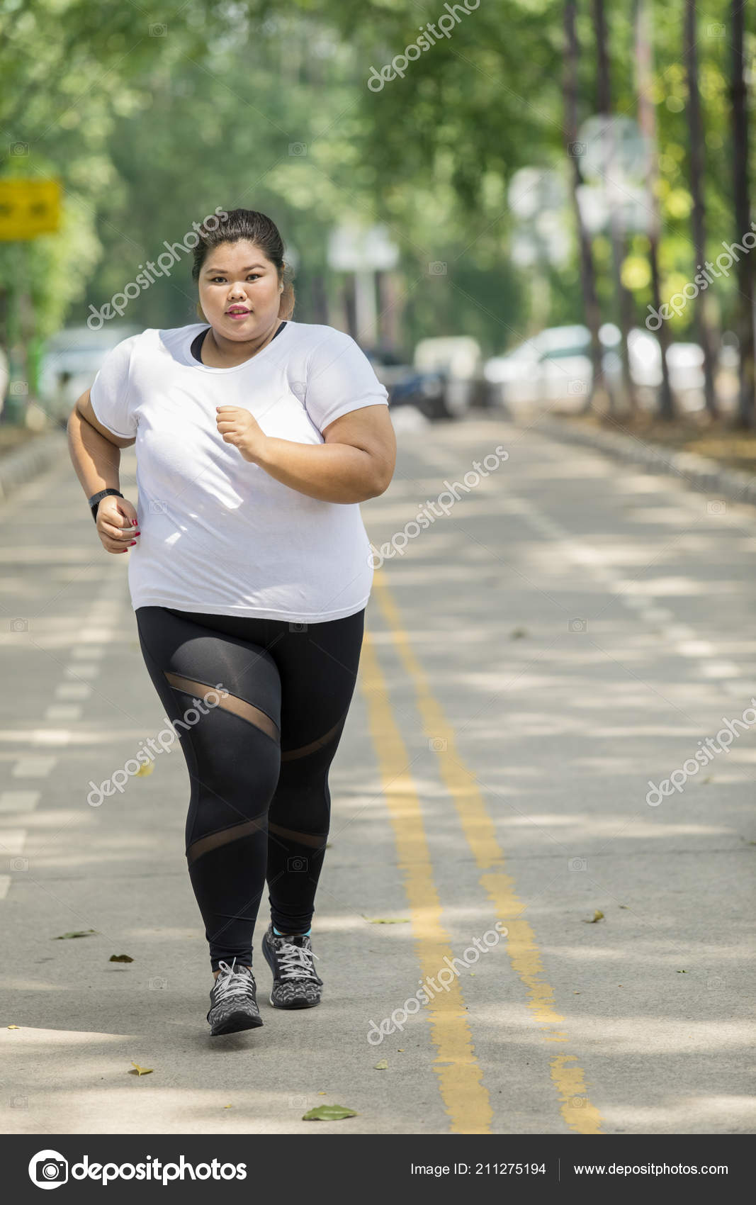 Portrait Grosse Femme Portant Des Vetements Sport Lors Jogging Sur Photo de stock par realinemedia 211275194