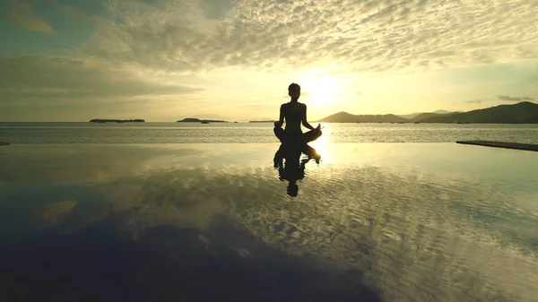 Siluett Ung Kvinna Gör Yoga Solnedgång Medan Mediterar Stranden Skjuten — Stockfoto