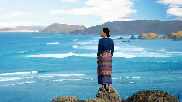 Merese 丘の上に立っている間海を楽しんでいる若い女性の背面します インドネシア ロンボク島で撮影 — ストック写真