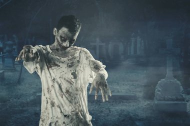 Halloween korku kavramı. Mezarı üzerine dolaşan bir tüyler ürpertici zombi adam resmi. Gece zaman vurdu