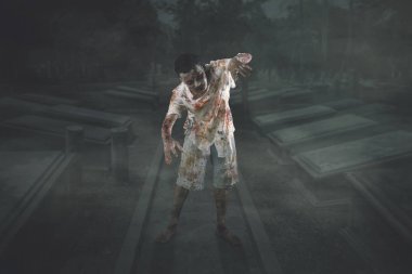 Halloween korku kavramı. Erkek Zombi Mezarlığı'yırtık kıyafetler ile yürüme resmi. Gece zaman vurdu