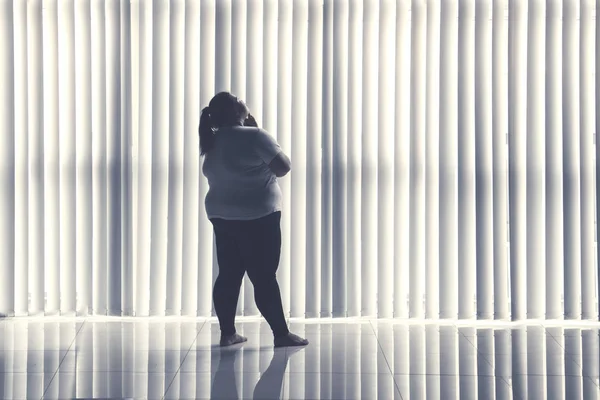 Rear View Pensive Obese Woman Standing Window Shot Home — Stock Photo, Image