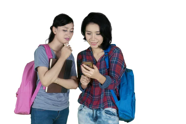 两名女大学生一起使用智能手机的图片 在白色背景下被隔离 — 图库照片