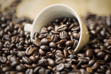 Kahvenin kahve fincanı ahşap masa üzerinde dökülmesini closeup