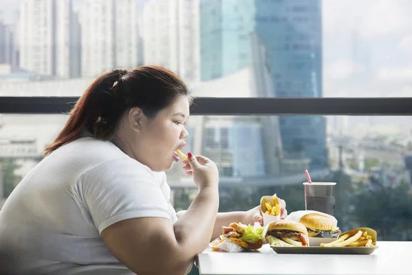 Obez Kadın Masada Hamburger Ile Restoranda Fransız Kızartması Yemek Yan — Stok fotoğraf