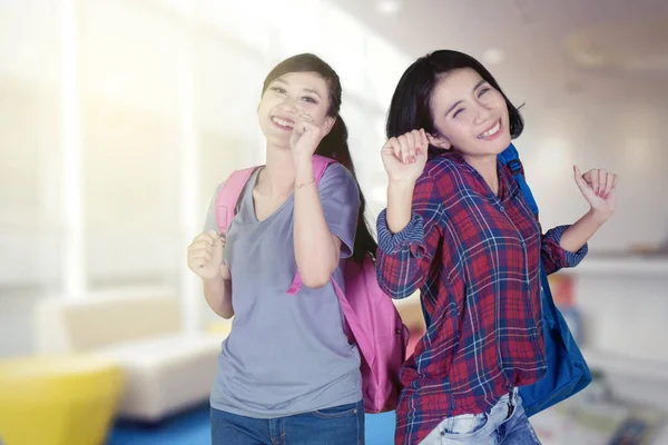 Estudiantes Universitarias Emocionadas Llevan Mochila Mientras Bailan Juntas Biblioteca — Foto de Stock