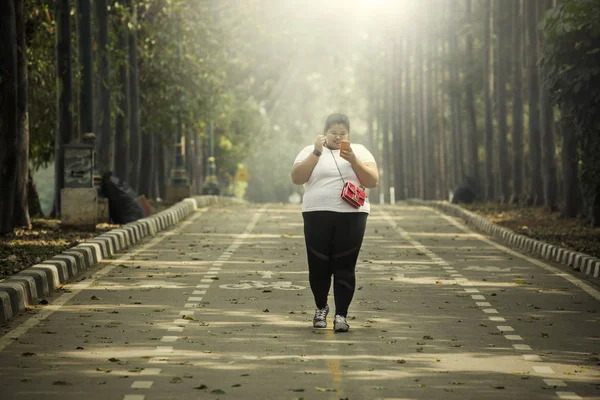 Imagem Uma Mulher Gorda Segurando Telefone Celular Enquanto Caminhava Estrada — Fotografia de Stock