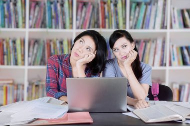İki kadın üniversite öğrencileri birlikte kütüphanede okurken bir fikir düşünüyorum