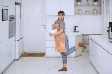 Çekici genç kadın evde mutfak oda içinde şarkı ve dans ederken bir hamur karıştırma