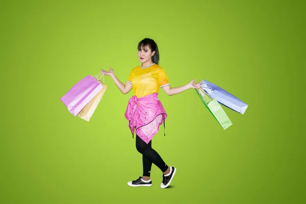美しい少女のイメージは 買い物袋を押しながら幸せそうに見えます 緑色の画面で撮影します — ストック写真