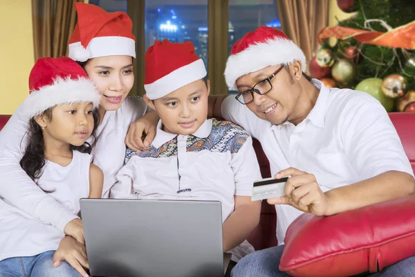 Obraz Młodego Rodziny Kapeluszu Santa Podczas Korzystania Karty Kredytowej Laptop — Zdjęcie stockowe