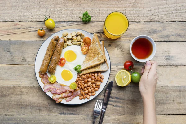 一个未知的女人的最高视图有一个美味的早餐与热茶和美味的饭菜桌上 — 图库照片