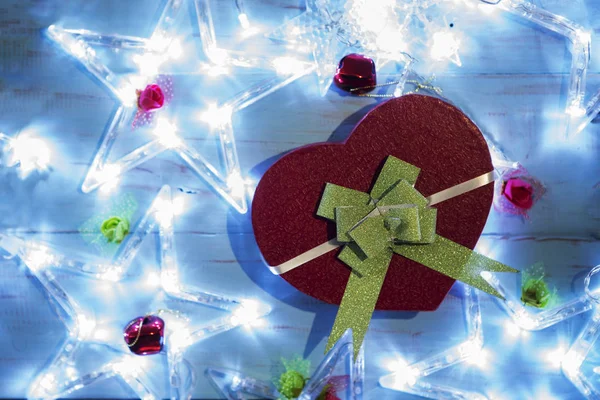 クリスマス ギフトの平面図形の星のクリスマス ライトの木製のテーブルと心 — ストック写真