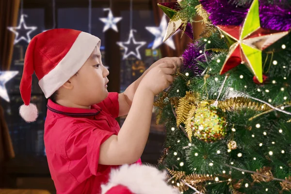 Menino Bonito Preparando Uma Árvore Natal Enquanto Vestindo Chapéu Papai — Fotografia de Stock