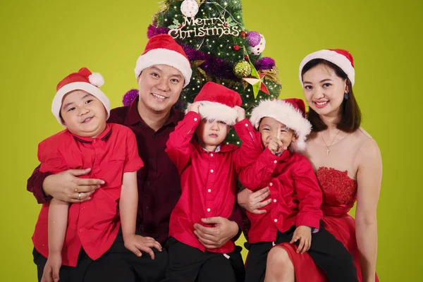 Foto Padres Jóvenes Sentados Con Sus Hijos Cerca Árbol Navidad —  Fotos de Stock