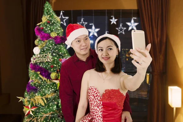 浪漫情侣照片在庆祝圣诞节的时候用智能手机拍照自拍照片 — 图库照片