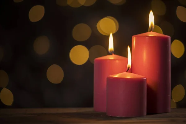 Image Three Red Candles Table Christmas Lights Blur Background — Stock Photo, Image