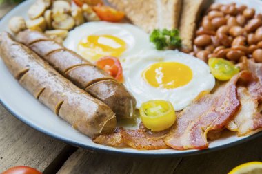 Lezzetli kahvaltı sosis, pastırma, yumurta, fasulye ve plaka üzerinde tost ile closeup