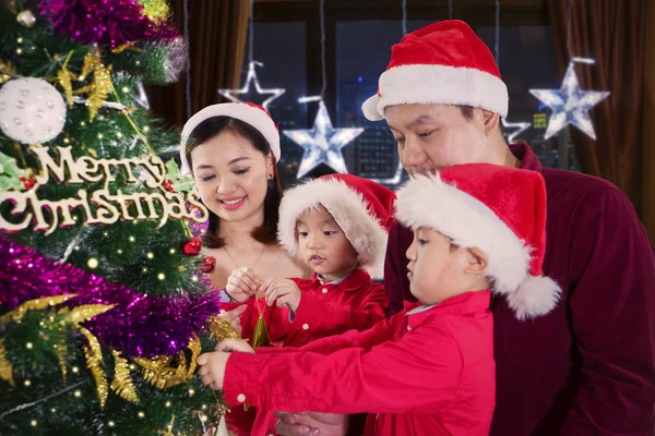 两个可爱的小孩子和他们的父母在家里装饰圣诞树的肖像 — 图库照片