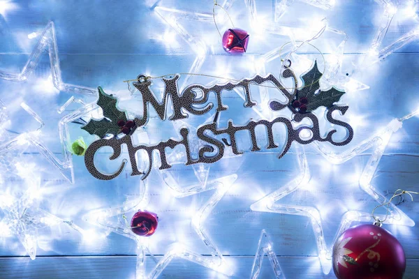 クリスマスの星と共にメリー クリスマス テキストのハイアングル ライト テーブルの上 — ストック写真
