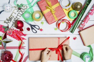 Kadın el Noel hediye kutuları ahşap masa şeritler ile süsle