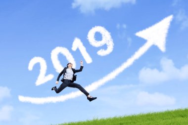 Güzel işkadını bulutlar ile atlama numarası 2019 ve mavi gökyüzünde yukarı ok şeklinde