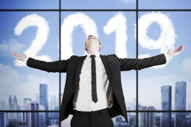 Beyaz işadamı numarası 2019 gökyüzünde şeklinde bulutlar ile ofiste dururken elleri uzanmış