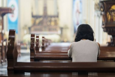 Arkadan görünüşü Hıristiyan kız kilisede otururken Tanrı'ya dua