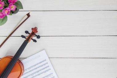 Ahşap masa üzerinde kopya alanı ile klasik keman ve müzik notlar sayfası yüksek açılı görünüş