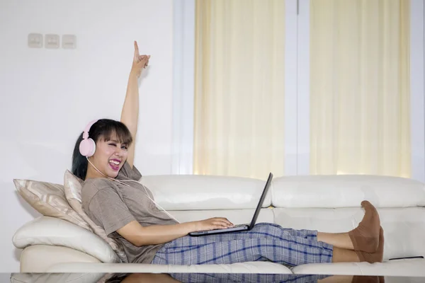 Вид Збоку Збудженої Жінки Слухає Музику Ноутбуком Навушниками Лежачи Дивані — стокове фото