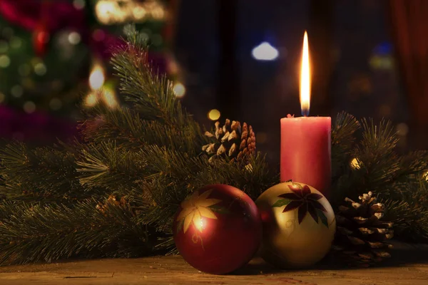 つの安物の宝石装飾品 クリスマスキャンドルぼやけているクリスマス ツリーの背景色の木製のテーブルの上のイメージ — ストック写真