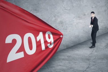 Resmi bir Arap Erkek Yöneticisi kırmızı bir kumaş numaraları 2019 ile çekmek için bir zinciri kullanma