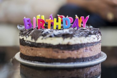 Tebrik masada evde çikolatalı Doğum günü pastası ile renkli mumlar