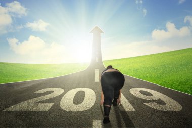 Şişman kadın numarası 2019 yolun sonunda yol yukarı ok şeklinde doğru doğru çalışırken yukarıda diz çökmüş görünümünü arka  