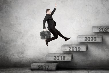 Görüntü doğru numaraları 2019 merdivenlerde yukarı tırmanma sırasında bir çanta taşıyan erkek girişimci