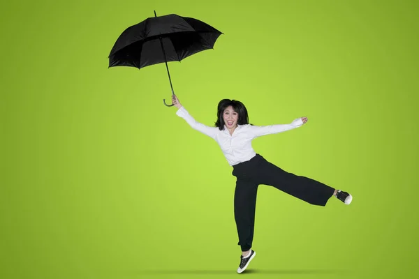 緑色の画面でスタジオに傘で踊る美しい実業家 — ストック写真