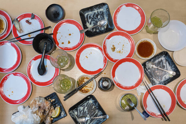 Top view of dirty dishes with food remnants on the wooden table